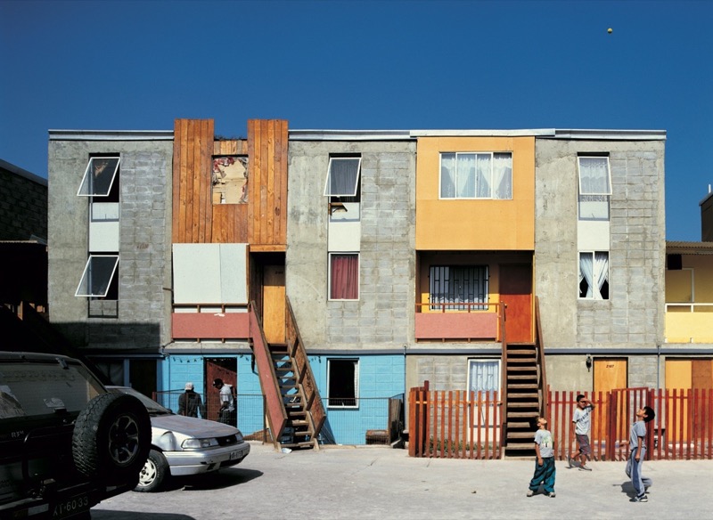 Iquique, Chile. Alejandro Aravena fikk internasjonal anerkjennelse for saneringen av slumkvartalet Quinta Monroy i 2004. Innovasjonen lå i levere halve hus som beboerne selv kunne ferdigstille når de fikk råd. Leilighetene var bygget som vertikale skoesker, tomrommet mellom dem ble fylt inn av senere utvidelser. Foto: Cristobal Palma / Elemental.