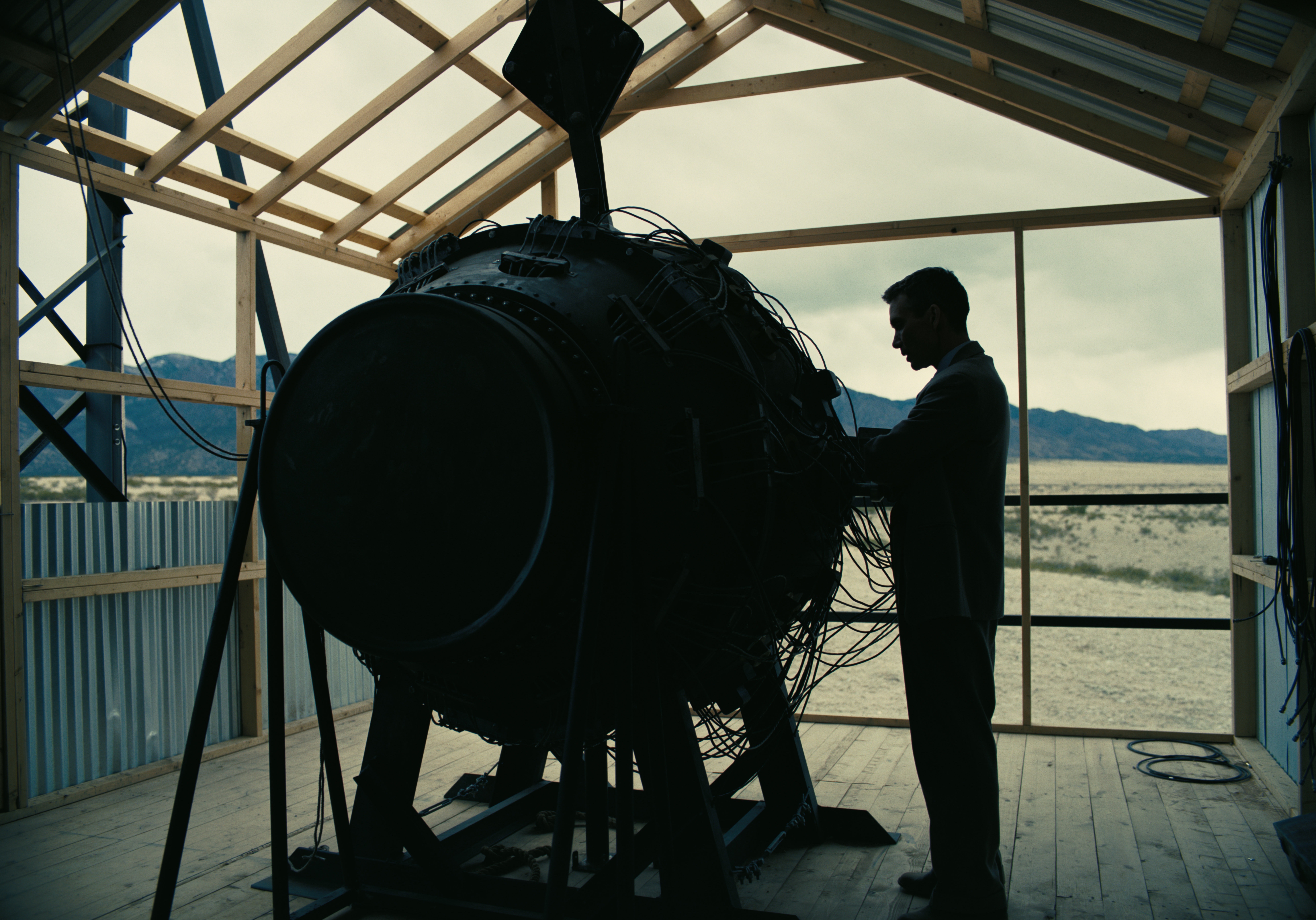 Illustrasjon fra filmen Oppenheimer, hvor hovedpersonen studerer en atombombe før en prøvesprengning.